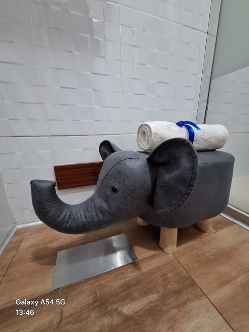 Elephant-shaped bathroom storage bench with rolled towels in Benavente hotel suite