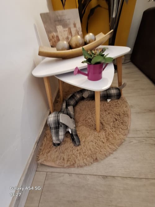 Scandinavian side tables with white tops, pink watering can with plant, and decorative items in Benavente rental