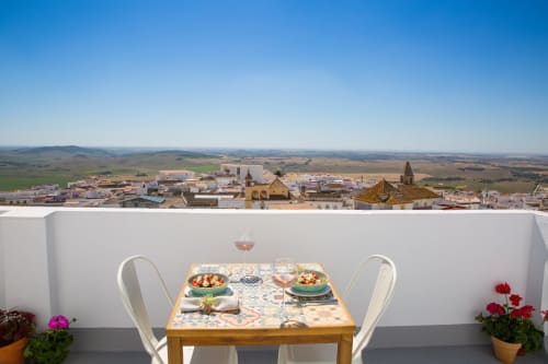 Comedor en terraza con vistas panorámicas de la arquitectura histórica de Medina Sidonia y el paisaje rural en Casa La