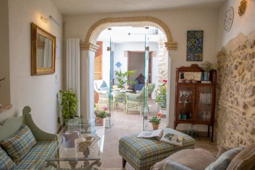 Salón elegante de la casa rural Casa La Muralla en Medina Sidonia, con puerta de arco que abre a la terraza