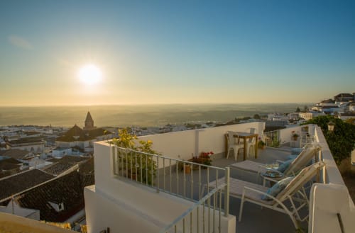 Terraza en azotea al amanecer en Casa La Muralla, Medina Sidonia, con vistas de la ciudad y campanario