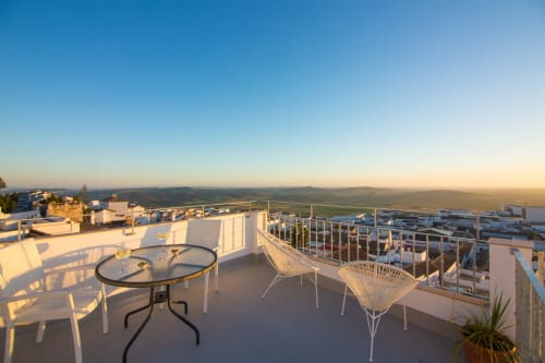 Terraza en azotea de Casa La Muralla en Medina Sidonia con zona de descanso, vistas al valle y luz de atardecer