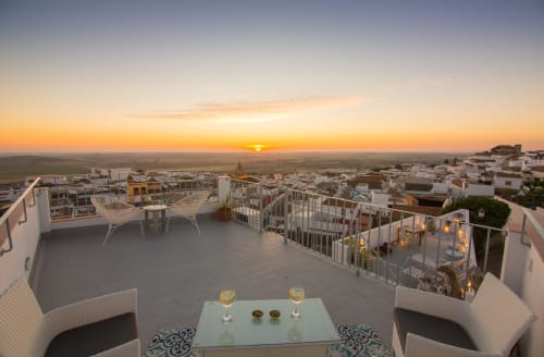 Atardecer en la terraza de Casa La Muralla en Medina Sidonia con vistas rurales, copas y arquitectura blanca