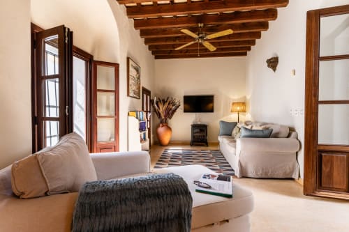 Amplio salón en la villa andaluza Casa de Medina con vigas de madera, chimenea, TV y cómodos asientos