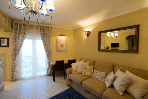 Acogedor apartamento estudio amarillo en La Vista Medina Stays con sofá, zona de comedor y balcón con vistas a Medina Sidonia