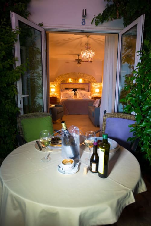 Zona de comedor al aire libre con vino y aperitivos con vistas al dormitorio elegantemente iluminado en La Vista de Medina, Medina Sidonia