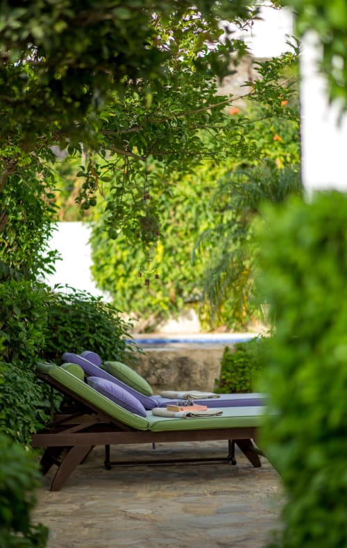 Exuberante patio ajardinado con asientos lounge acolchados en La Vista Medina Stays, Andalucía