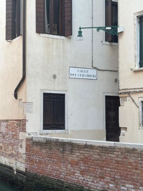 Affascinante ingresso di via veneziana al Casanova Hideaway BnB con lampada verde e insegna Calle dei Cerchieri
