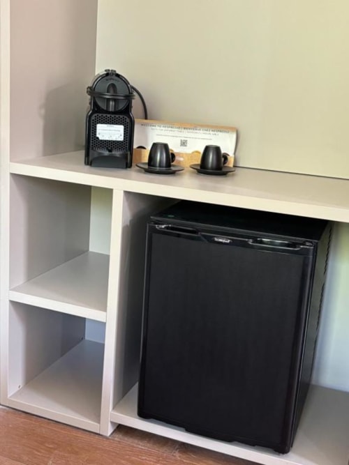 Caffettiera e accessori su scaffale sopra mini frigorifero nella camera Casanova Hideaway Venice