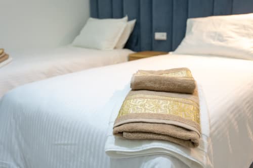 Neatly folded towels arranged on a bed in a double room at Riad Gold Hôtel, Azrou