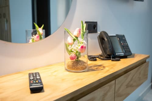 Riad Gold Hôtel reception desk with pink tulips in glass vase, telephone, and remote control in Azrou, Morocco