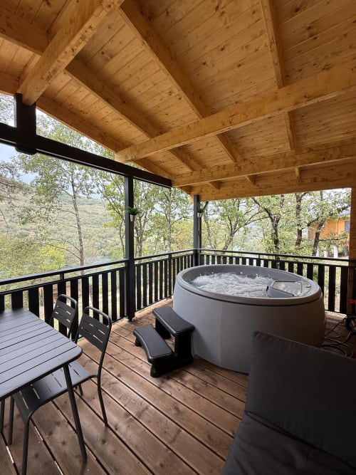 Vasca idromassaggio su terrazza in legno al lodge Bruyere con vista sulla valle di Serrières-sur-Ain e le montagne
