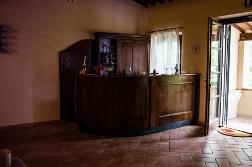 Recepción del B&B Il Casale di David en Pontedera, con mostrador de madera curvo y paredes amarillo cálido
