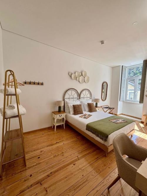 Tinta Cao double bedroom at Casa Tawny in Pinhão with metal bed frame, wooden floors, and mountain view balcony
