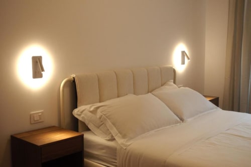 Elegante camera matrimoniale a Le Dimore Del Duca Roma con testata illuminata, biancheria crema e arredamento minimalista moderno