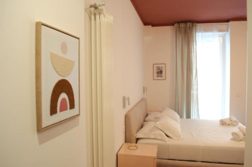 Moderna camera tripla con balcone al Le Dimore Del Duca Roma, con arredamento minimalista, biancheria color crema e tonalità terra calde