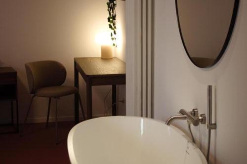 Bagno moderno con vasca indipendente, specchio ovale e zona salotto al boutique hotel Le Dimore Del Duca Roma