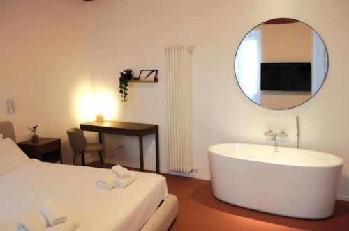 Suite quadrupla presso Le Dimore Del Duca Roma con vasca indipendente, scrivania, letto e specchio rotondo