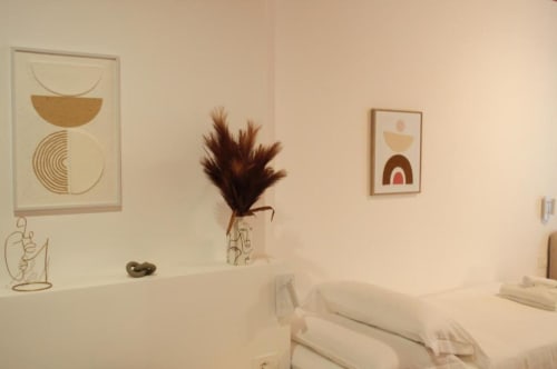 Camera da letto minimalista moderna presso Le Dimore Del Duca Roma con arte astratta alle pareti, decorazioni di erbe pampa secche e biancheria bianca