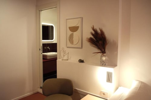 Scrivania moderna in camera d'hotel con specchio LED, vaso decorativo di erba pampas e opera d'arte presso Le Dimore Del Duca Roma
