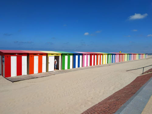 Colorful beach huts line the sandy beach in Bourbourg, France near Cosyade hotel