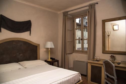 Elegant double room at Hotel San Giovanni Resort in Saluzzo with landmark view, white bedding, desk, and classic furnishings