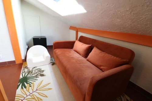 Chambre mansardée cosy à l'Hôtel Villa Roseraie avec canapé rouille, puits de lumière et équipements modernes à Vence