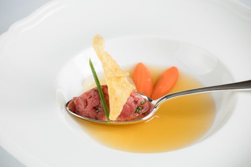 Plato gourmet del Resort Hotel San Giovanni en Saluzzo: tartar de res, teja crujiente y guarnición de zanahoria