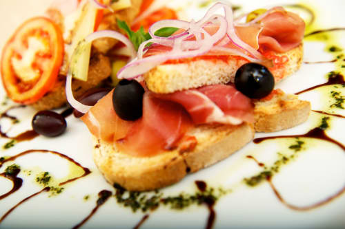Elegantes bruschettas gourmet con salmón ahumado, alcaparras y cebolla rosada en La Vista Medina Stays