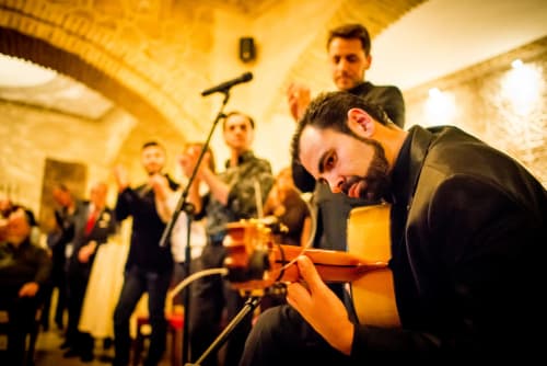 Músico tocando guitarra acústica en el evento La Vista Medina Stays en Medina Sidonia, España