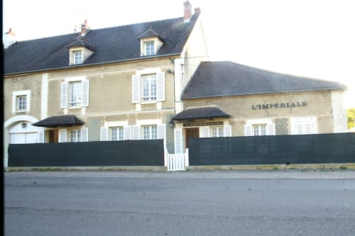 L'Impériale B&B exterior in Sermizelles, France - stone townhouse with black gates and white shutters