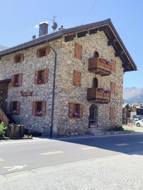 Storico hotel Al Dos a Livigno con balconate in legno e vista sulle montagne