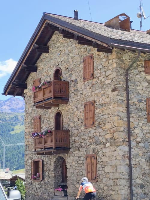 Tradizionale edificio in pietra a Livigno con balconate in legno e vista sulle montagne, hotel Al Dos