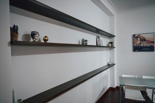 Mensole moderne in appartamento con oggetti decorativi e quadro con veduta di Venezia in affitto a Roma