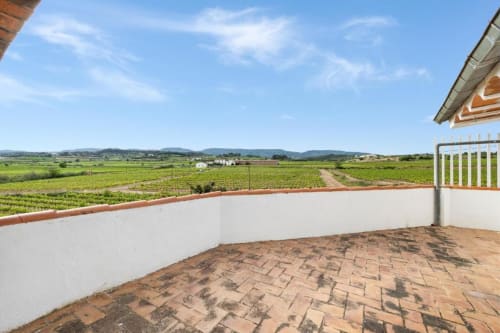 Brick terrace balcony overlooking green vineyards and mountains at Masia Rural Ca l'Eloi Janet villa near Barcelona