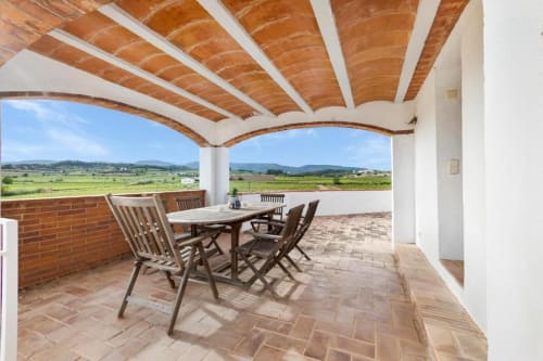 Covered terrace with dining furniture overlooking mountain views at Masia Rural Ca l'Eloi Janet villa near Barcelona