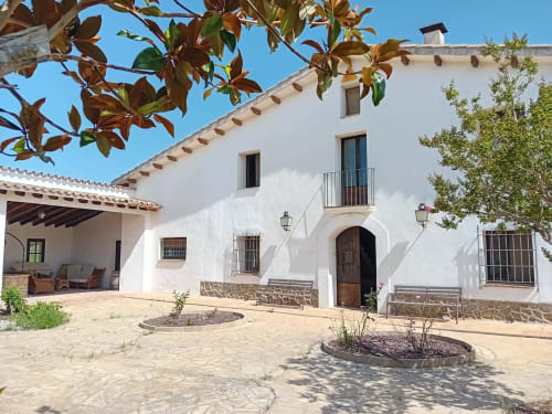 Cortijo Rural Ca l'Eloi Janet en Barcelona: edificio encalado, detalles en piedra y arquitectura rústica