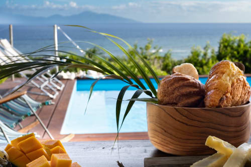 Petit-déjeuner chez Marie et Philippe : pâtisseries, fruits tropicaux et vue sur l'océan dominant la piscine de Marie-Galante