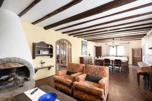 Sala de estar rústica en Masia Rural Ca l'Eloi Janet cerca de Barcelona con chimenea y vigas de madera vista