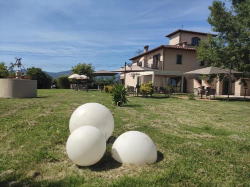 Jardín de casa rural toscana con esferas decorativas blancas, villa, terrazas y vistas a las montañas en Pontedera