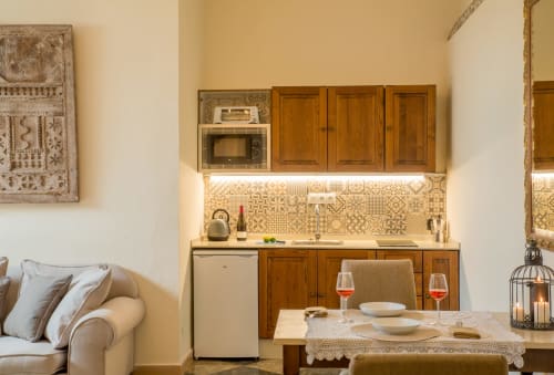 Modern apartment kitchen and dining area at La Vista Medina Stays with wooden cabinets, patterned backtile, and dining setup