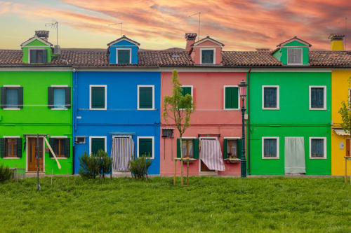 Affascinanti case colorate al Casanova Hideaway B&B di Venezia con facciate verde, blu e rosa vivaci sotto un cielo al tramonto