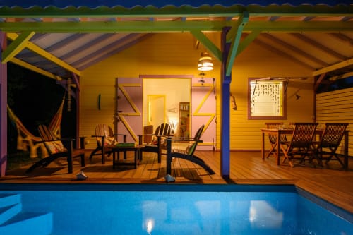 Villa Ti'Kaz Vanille à Marie-Galante avec terrasse illuminée, piscine privée, transats et coin repas au crépuscule
