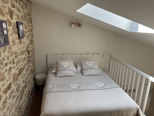 Cozy bedroom in Suite du Meunier at Logis De La Bénétière, Treize-Vents, with queen bed, skylights, and stone walls