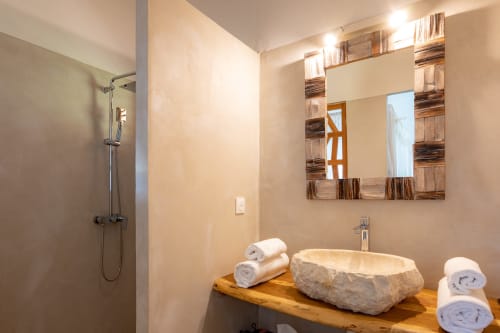 Salle de bain moderne à Chez Marie et Philippe, Guesthouse Aïchi, Marie-Galante avec lavabo en pierre et meuble vasque en bois