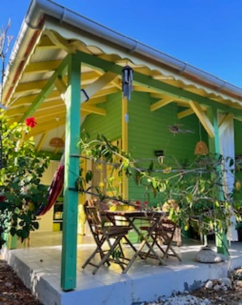Charmante maison Ti'Kaz Citron aux murs verts et bordures jaunes chez Marie et Philippe à Marie-Galante, vue sur le jardin