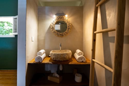 Vasque en pierre et miroir rond décoratif dans la salle de bains moderne de Chez Marie et Philippe, plan de travail en bois