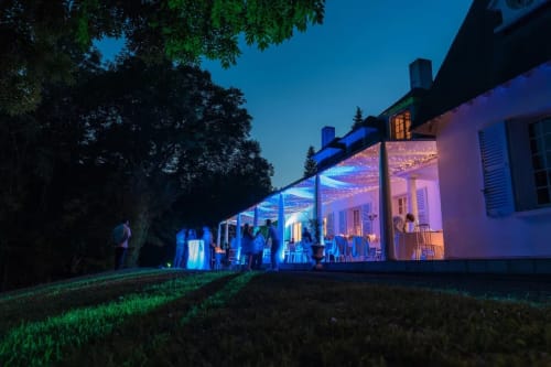Abendveranstaltung auf Domaine de Bize Mirepoix mit blau beleuchteter Außenpavillon, Gäste auf dem Rasen, Veranstaltungsort in Ariège