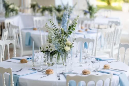 Eleganter Hochzeitstisch im Domaine de Bize mit blauen und weißen Blumendekoration, Gedeck und Glässern