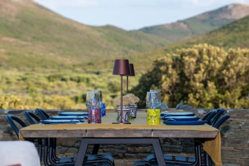 Salon de jardin avec chaises bleues surplombant les montagnes à la Villa Camille, Centuri